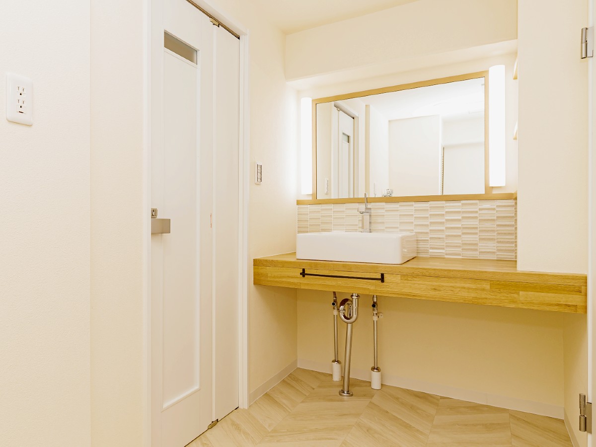 奥様が化粧できるドレッサー代わりに洗面カウンターを拡大して、照明も正面から当たるようにしています。下のオープンなスペースは、ご自身たちで住みながらレイアウトを考えたいとおっしゃっていました。